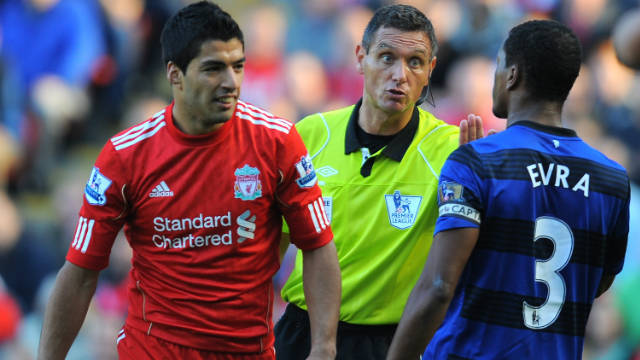 Referee Andre Marriner (C) talks to Liverpool's Luis Suarez (L) and Manchester United's Patrice Evra at Anfield on Saturday.