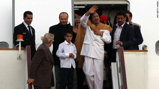 Gadhafi exits a plane in Tripoli with family members and bodyguards after traveling to the United States and Venezuela in 2009.