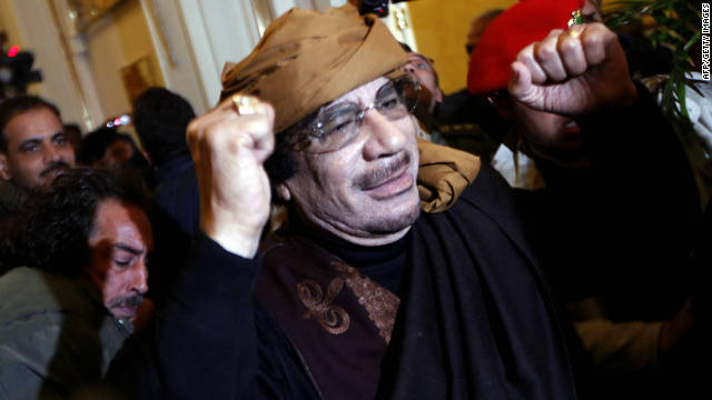 Gadhafi smiles and raises his arms as he enters the Rixos Hotel in Tripoli on March 8, 2011.
