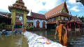 Thai buddhist monks walk through floodwaters in Bangkok on October 29, 2011. 