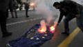 A Greek student sets fire to the flag of the European Union 