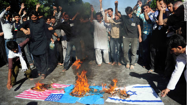 Demonstrators burn U.S., NATO and Israeli flags during a religious procession in Karachi, Pakistan, on Monday. 