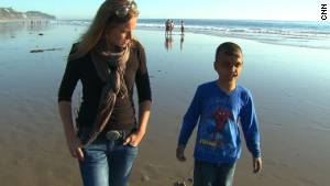 Youssif walks along the California beach with CNN\'s Arwa Damon, who first told the boy\'s story in 2007.