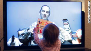 Harper holds a book up to the TV as she and her mother, Alexandra, Skype with her father, in November.