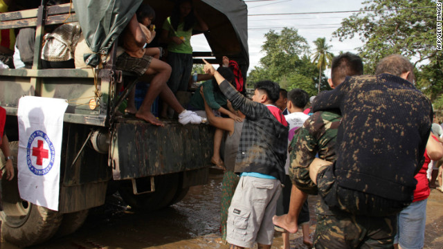 Military personnel help evacuate residents from a village in Iligan City on Saturday, December 17, after Tropical Storm Washi struck in the southern Philippines. Flash floods and mudslides from the storm killed hundreds.