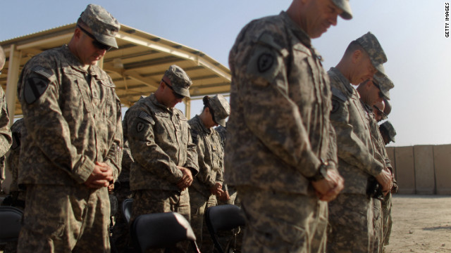 Soldiers from the 3rd Brigade, 1st Cavalry Division bow their heads in prayer during a casing of the colors ceremony while preparing to depart from Iraq at Camp Adder, now known as Imam Ali Base, near Nasiriyah, Iraq.