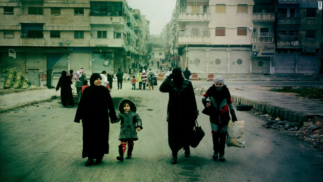 Despite the threat from snipers, a family makes its way down Cairo Street in Al Khaledia in Homs, Syria.