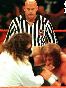 Um tempo de Minnesota governador, ex-lutador profissional e convidado árbitro Jesse Ventura, centro, observa a ação durante a World Wrestling Federation SummerSlam em 1999, em Minneapolis.