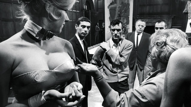 Hugh Hefner evaluates Bunny outfit alterations at the Chicago Playboy Mansion in 1965.