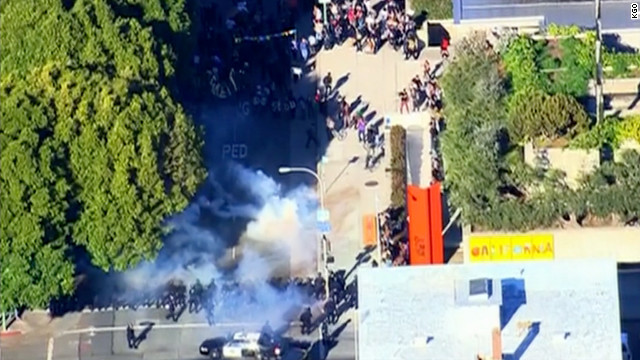 Smoke rises between Occupy Oakland protesters and police cordoning off an intersection Saturday.
