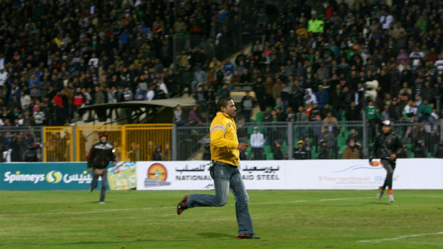 An Al-Masry fan invades the pitch during the match in Port Said.