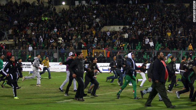 Egyptian football fans rush on to the field during the clashes.