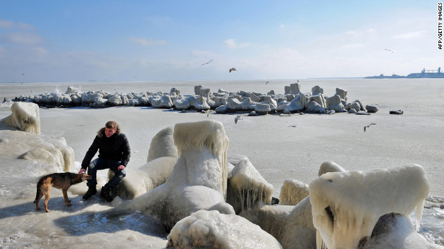 <br/>A man pets a dog next to frozen sea waters in Constanta, Romania, on Wednesday, February 1. Temperatures plunged to -34 degrees Celsius (-29 degrees Fahrenheit) in central Romania, where eight people died due to cold-related causes, according to local media.