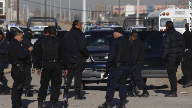 Municipal police officers in Ciudad Juarez, Mexico, collect evidence from a shooting that left colleague Julian Juarez Baena dead