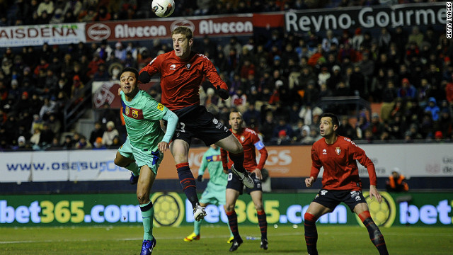 Barcelona's Thiago Alcantara (L) duels for a high ball with Sergio Fernandez of Osasuna during Saturday's La Liga match.