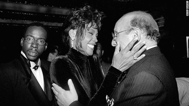 Bobby Brown, left, looks on as his wife, Whitney Houston, congratulates Clive Davis, president of Arista Records, at a 1995 benefit dinner for Davis. 