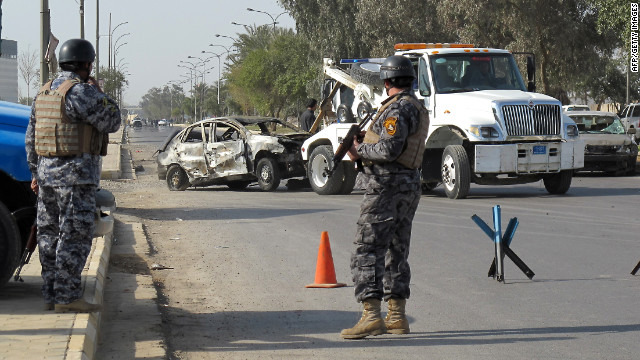 Iraqi policemen stand guard outside a Baghdad police academy that was the target of a suicide car bombing on Sunday.