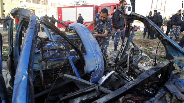 A Hamas policeman inspects the remains of a vehicle that was targeted by an Israeli airstrike in Gaza City.