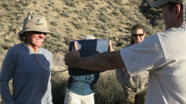 An executive participant strains before breaking an arrow pressed against her throat on a Be Legendary retreat in the desert in Nevada, USA.