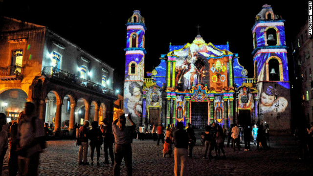 Cubans watch a projection with images of Pope Benedictus XVI on the walls of Havana's Cathedral, on March 25, 2012. 