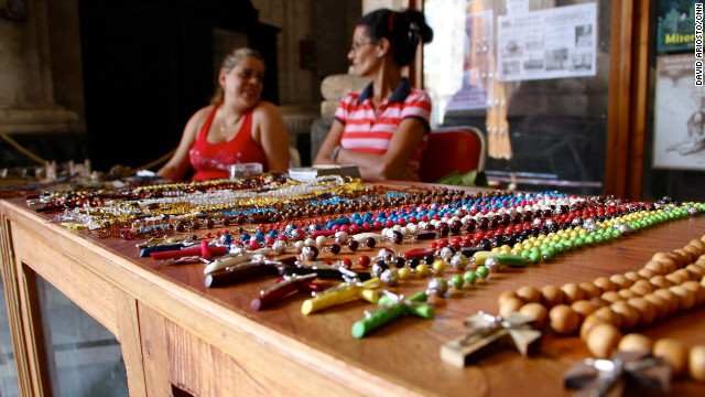 Two women sell crucifixes to tourists.