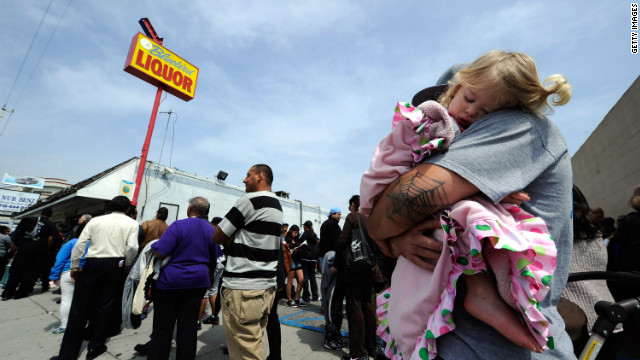 One year-old Karissa Sanchez sleeps on her father Chris' shoulder as they have been waiting over three hours to buy their Mega Millions lottery tickets at Bluebird liquor store.