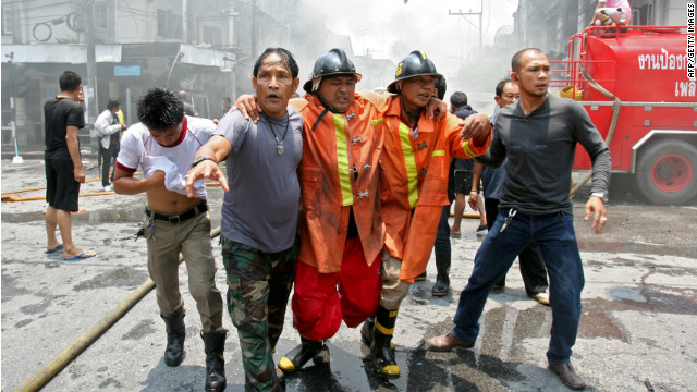 An injured fireman is helped from the scene of a car bomb blast in Yala, Thailand.