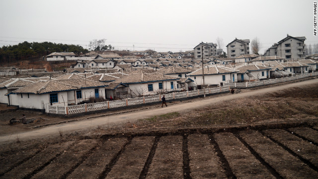  A North Korean soldier is seen from the window of a train Sunday as he walks near a small town along the railway heading from Pyongyang to the North Pyongan Province on the west coast.