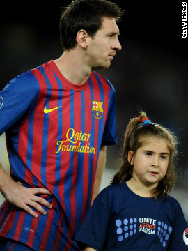 Three-time world player of the year Lionel Messi with a mascot wearing an anti-racism shirt ahead of Barcelona's UEFA Champions League match against Czech team Viktoria Plzen in October 2011.