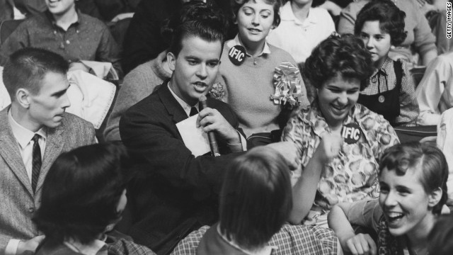 "American Bandstand" host Clark, pictured in 1958, surrounded by audience members.