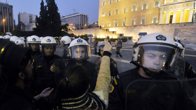 A woman points at the parliament building during a protest in front of the Greek parliament on April 5, 2012.