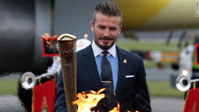 David Beckham lights the torch as it arrives at RNAS Culdrose airbase in Cornwall, England, on May 18. The footballer was part of a British delegation that flew back with the flame from Greece.