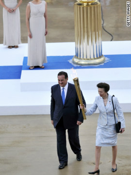 Queen Elizabeth II's daughter, Anne, the Princess Royal, receives the flame from Olympic chief Spiros Kapralos at a handover cermony in Athens on May 17.