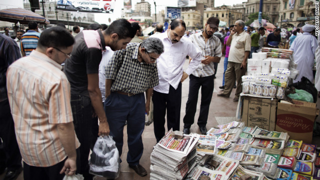 Egyptians read the front page of newspapers for sale outside of Al-Fatah Mosque in Cairo on Friday.