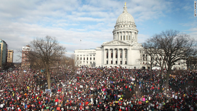 Thousands of demonstrators gather outside the Wisconsin State Capitol in Madison the following day to protest the bill signing.