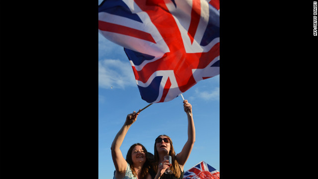 Spectators wave Britain's Union flag in London's Hyde Park as they watch the Diamond Jubilee Concert.