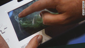 The Wii U\'s handheld controller displays a game during a presentation by developers Ubisoft.