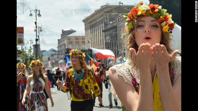 A young woman blows a kiss as she takes part in a parade before the opening match.