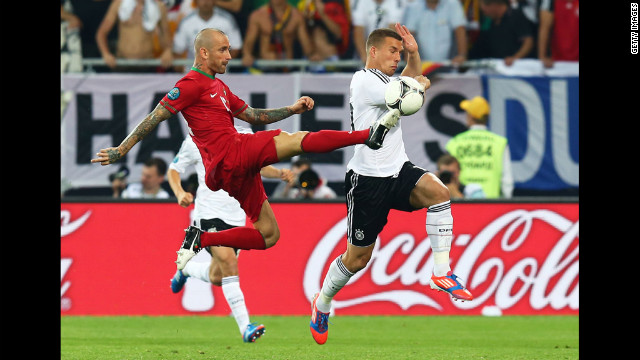 Lukas Podolski of Germany and Raul Meireles of Portugal battle for the ball.