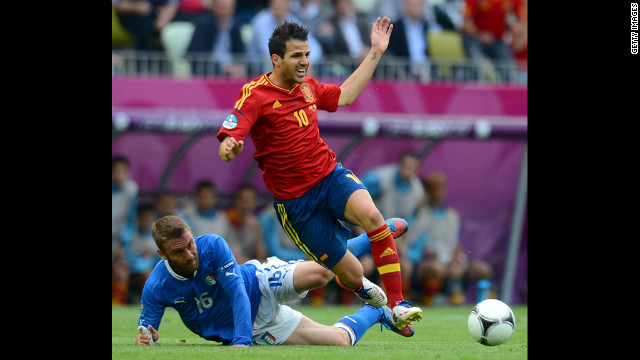 Daniele De Rossi of Italy tackles Cesc Fabregas of Spain.