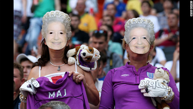 England fans wearing Queen Elizabeth II masks watch the match against France on Monday.