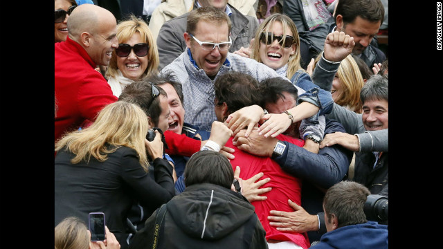 Nadal is embraced by friends and family in the stands after his victory.