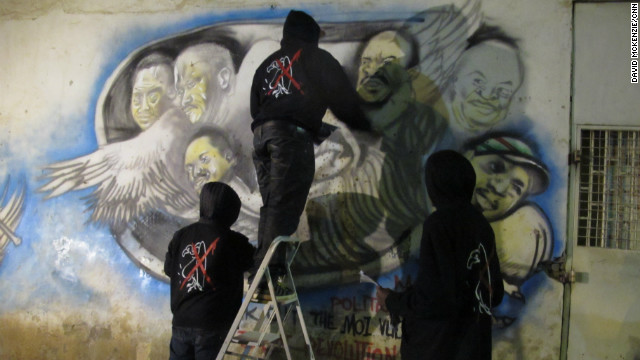 Graffiti artists work on the details of their latest piece in Nairobi, Kenya. They paint political art highlighting corruption and compare national leaders to vultures.