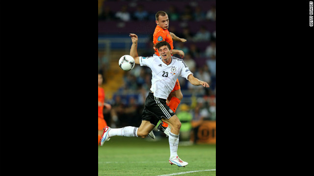 John Heitinga of the Netherlands and Mario Gomez of Germany fight for the ball.