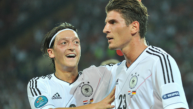 Germany striker Mario Gomez is congratulated by midfielder Mesut Oezil after scoring the first of his two goals