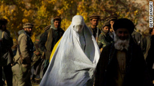 A woman wearing a traditional burqa flees the village of Khanabad U.S. warplanes drop bombs on Taliban positions in 2001.