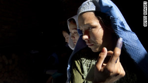 An Afghan woman shows off her ink-stained finger before casting a vote in Kabul in elections in September 2010.