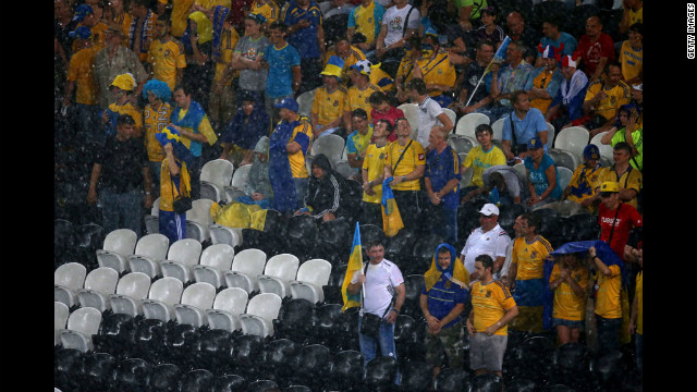 Fans endure the rains during the match between Ukraine and France on Friday.