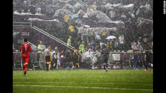 Players leave the field Friday after weather caused the Ukraine vs. France game to be suspended.