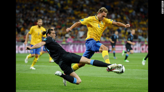 Andreas Granqvist of Sweden is tackled by Andy Carroll of England during the Sweden-England matchup.